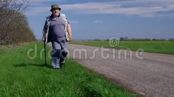 大风春天一位手持拐杖在路边徒步行走的老人视频的预览图