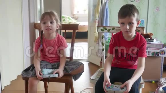 孩子们玩电子游戏控制器游戏本室内控制台男孩和女孩在网上玩游戏视频的预览图