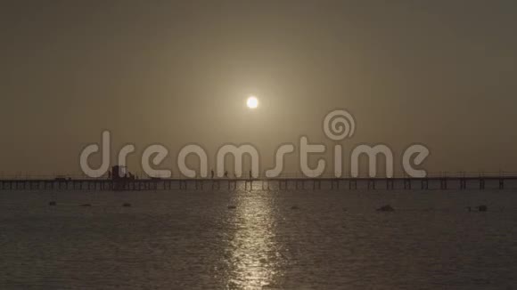 人们沿着码头散步的剪影傍晚海上日落视频的预览图