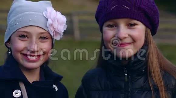 两个漂亮的小女孩看着摄像机微笑着视频的预览图
