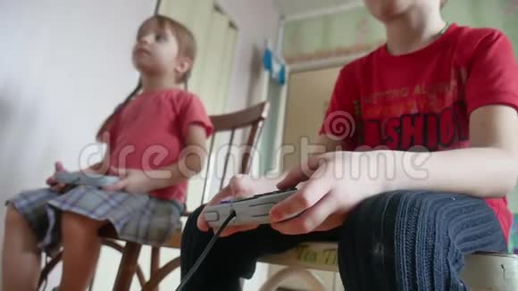 孩子们在室内玩电子游戏控制器游戏男孩和女孩在网上玩游戏视频的预览图