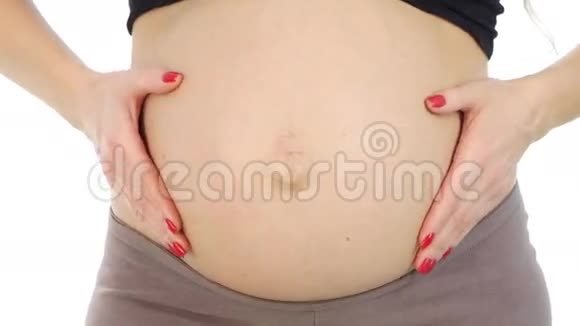 孕妇在怀孕的腹部白色特写的时候双手呈心形视频的预览图