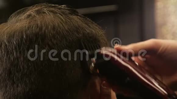 理发师用剪头发剪客户理发师的头发视频的预览图
