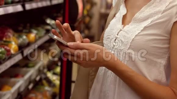 女人在购物时用手机视频的预览图