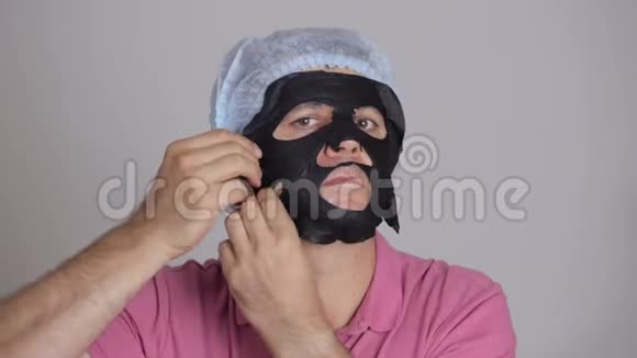 男45岁脸上涂了一张恢复活力的化妆品黑组织面膜视频的预览图