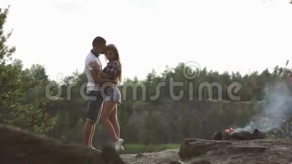 爱旅行的情侣拥抱在森林露营地与篝火放松视频的预览图