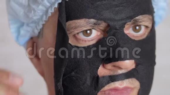 男45岁脸上涂了一张恢复活力的化妆品黑组织面膜视频的预览图
