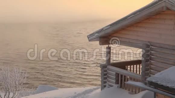 黎明时分冬日海边的木屋视频的预览图