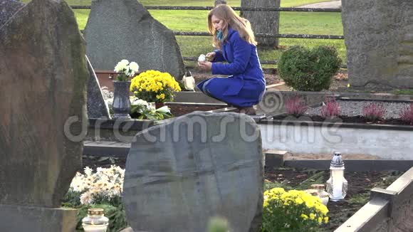 年轻女子点燃蜡烛灯笼纪念墓地里的丈夫父亲4K视频的预览图