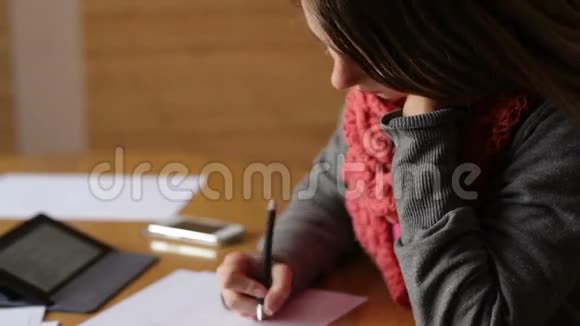 办公室里漂亮的年轻女子用钢笔写字视频的预览图