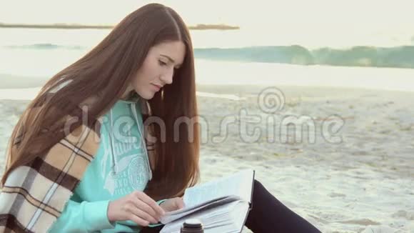年轻女子在海边看书喝热茶视频的预览图