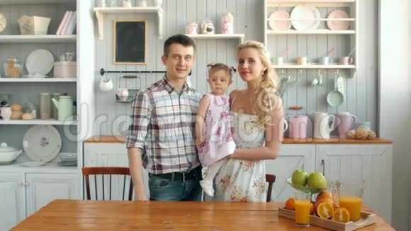 爸爸妈妈和女儿在厨房做饭家庭幸福爸爸妈妈和女儿早上视频的预览图