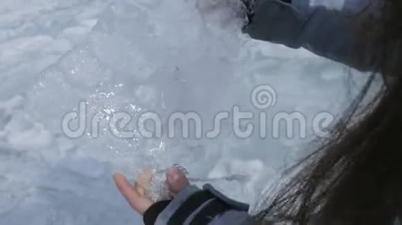 女人手里拿着橡胶冰移动它使它在太阳上发光视频的预览图