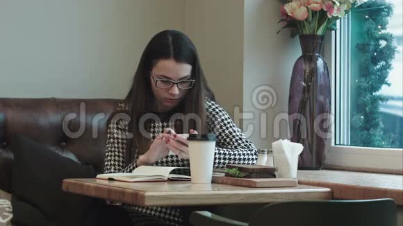 在咖啡馆或餐馆工作的年轻商务女性午休时带笔记本视频的预览图