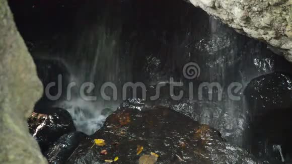 森林岩石后面的洞穴瀑布视频的预览图
