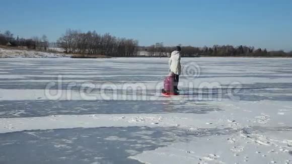 母亲和女儿在冰冻的湖面上滑行视频的预览图