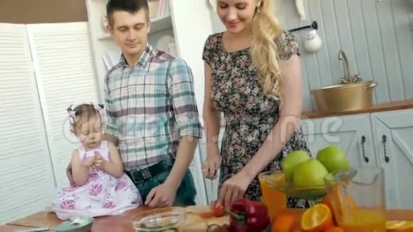 母亲和孩子在厨房里玩蔬菜在厨房里准备午餐视频的预览图