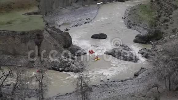 四对人乘着双船体的小船顺着野河奔流而下随波逐流视频的预览图