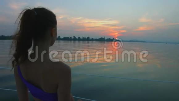 女孩在河上欣赏日落视频的预览图