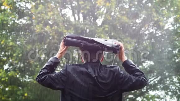 商人在雨中躲在包下视频的预览图