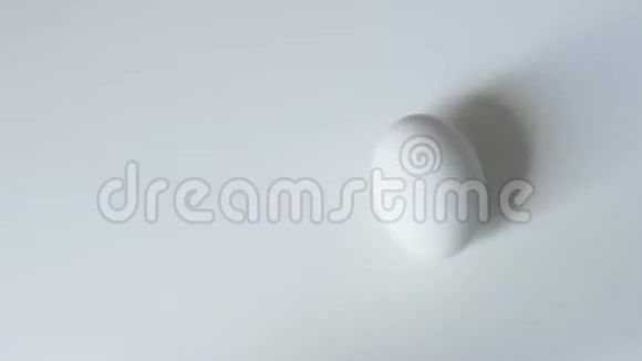 鸡蛋旋转鸡蛋旋转白色背景顶部视图蛋在白色背景上旋转和滚动快乐视频的预览图