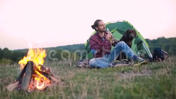 人类与狗一起旅行在大自然中露营视频的预览图