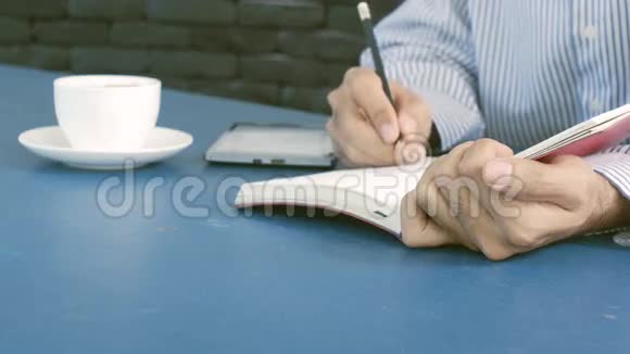 商人用平板电脑和一杯咖啡在素描书上勾勒出这个想法视频的预览图