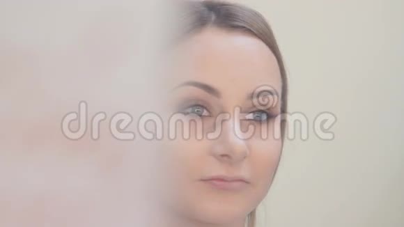 在美容院设计眉毛女孩眼影用刷子涂眉毛视频的预览图