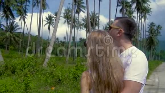 浪漫的情侣在棕榈林接吻视频的预览图