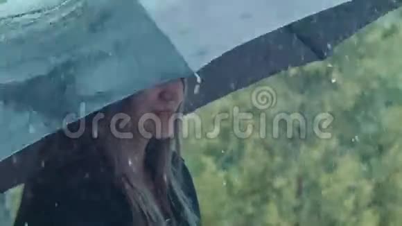 金发女人在雨下拧伞视频的预览图