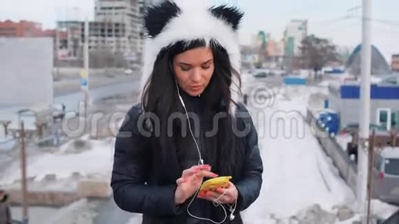美丽的卷发黑发摩洛哥女人在城里使用智能手机视频的预览图
