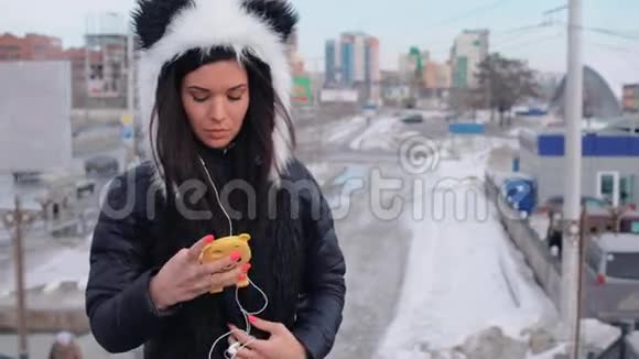 美丽的卷发黑发摩洛哥女人在城里使用智能手机视频的预览图