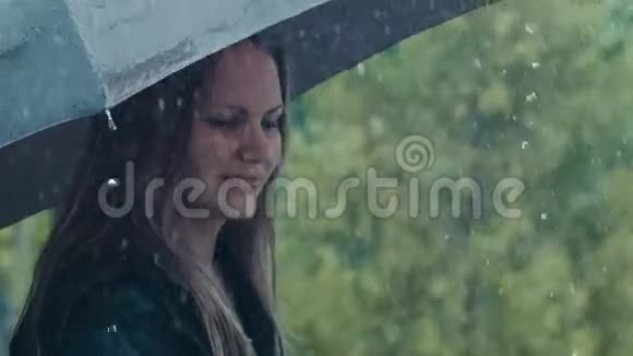 伞下的金发女人淅淅沥沥的雨滴视频的预览图