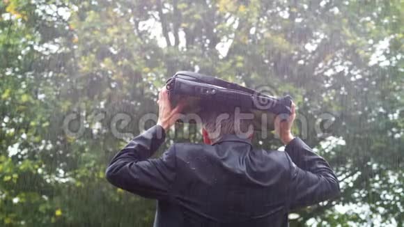 商人在雨中躲在包下视频的预览图