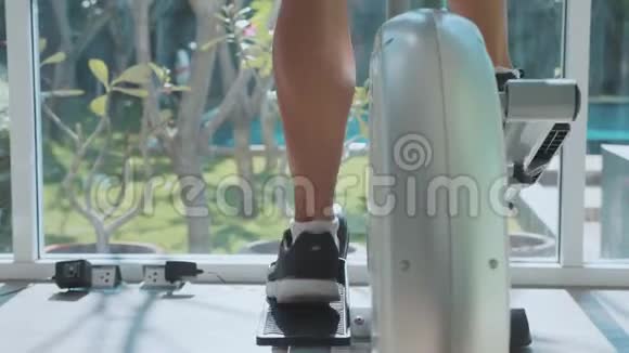 运动的年轻女子在健身房里慢动作的踩步机锻炼视频的预览图