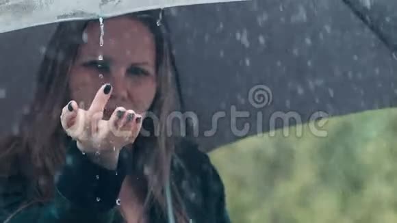 伞下的金发女人淅淅沥沥的雨滴视频的预览图