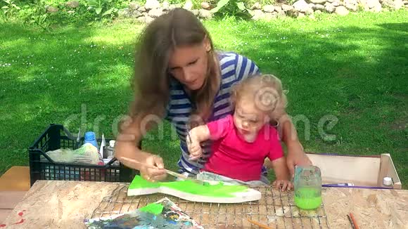 妈妈带着她蹒跚学步的女儿女儿画了木鱼装饰视频的预览图
