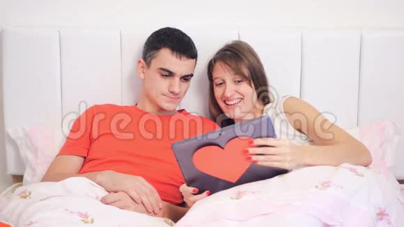 年轻夫妇正在看手提电脑视频的预览图