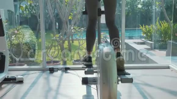 运动的年轻女子在健身房里慢动作的踩步机锻炼视频的预览图