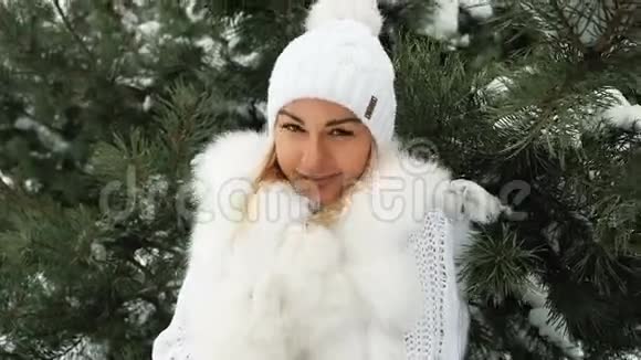 穿着白色连衣裙的年轻女子在云杉下结冰微笑着视频的预览图