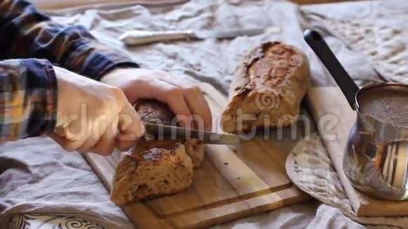 面包和烘焙食品特写男性村民在亚麻桌布上切面包在村子里吃早餐自制视频的预览图