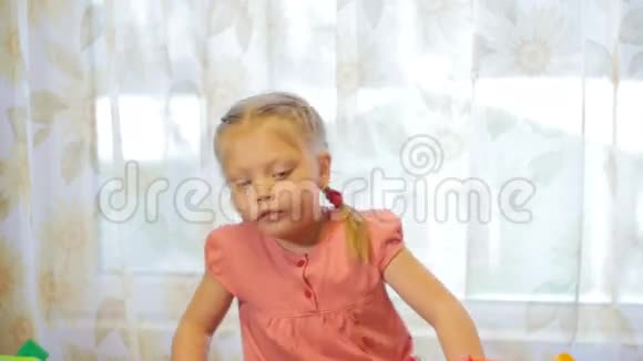 一个小女孩玩玩具积木的肖像垂直平底锅视频的预览图