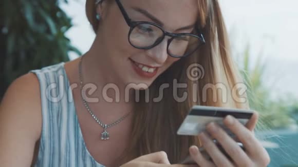 漂亮的女人用信用卡和手机购物视频的预览图