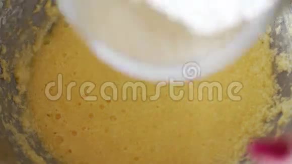 女人把面粉和柠檬皮倒入面团中用来做蛋糕和搅拌视频的预览图