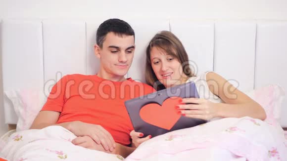 年轻夫妇正在看手提电脑视频的预览图