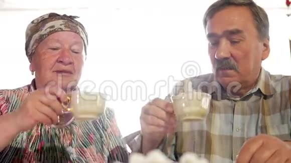 一对老夫妇正在喝一杯老式俄罗斯水壶萨莫瓦尔的茶一个留胡子的男人和他妻子在视频的预览图