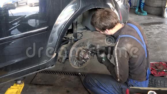 在车库修理汽车刹车系统的细心工人视频的预览图