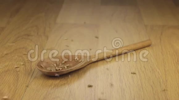 一粒黑麦落在木勺上躺在木面上视频的预览图