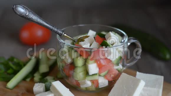 沙拉配蔬菜和奶酪配料用勺子搅拌视频的预览图
