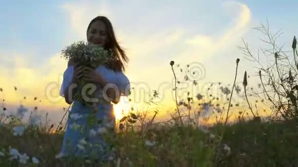 女孩站在田野里手里拿着一束白色的花视频的预览图